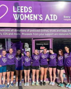 The UOLWCC members smiling outside LWA charity shop in LWA tshirts